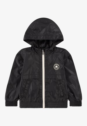 Black windbreaker jacket with a hood, front zipper, elastic cuffs, and two side pockets; features a circular logo patch on the chest.