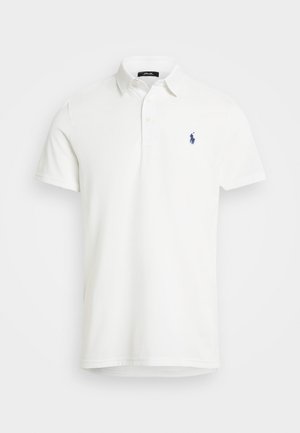 Hvit polo-skjorte laget av glatt bomull, med klassisk krage, korte ermer og en marineblå brodert logo på venstre bryst.