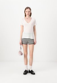 Hvid V-hals t-shirt, sort og hvid stribede shorts, pink taske, sorte sko, hvide sokker. Minimalistisk design med bløde teksturer og karakteristiske mønstre.