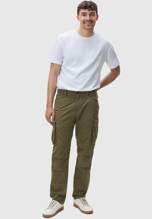 Olivgröna cargobyxor med sidofickor, bälteöglor och en avslappnad passform, kombinerade med en enkel vit t-shirt och vita sneakers.