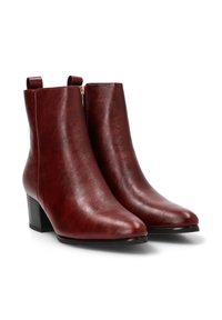 Botas de tobillo burdeos de cuero suave, con puntera afilada, un tacón bajo y un cierre lateral para facilitar el uso.