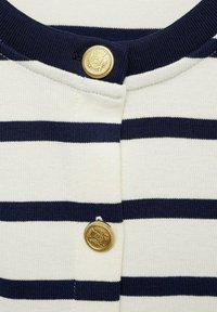 Pull rayé bleu marine et blanc avec un col rond et des boutons décoratifs dorés à l'avant. Tissu doux avec des accents côtelés.