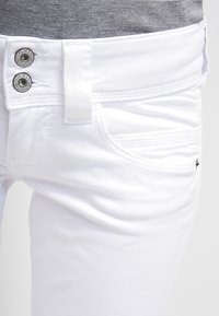 Valkoiset farkut, joissa on sileä pinta, kapea malli, kaksi etutaskua ja metalliset napit, joissa on "Pepe Jeans London" -brändäys.