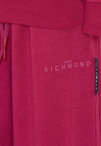 Felpa con cappuccio in cotone fucsia con orlo e polsini a coste, chiusura con coulisse e logo "JOHN RICHMOND" in rilievo sul davanti.