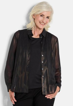 Zwarte, doorzichtige button-up shirt met een subtiele textuur, lange mouwen en een klassieke kraag, gelaagd over een effen zwart top.