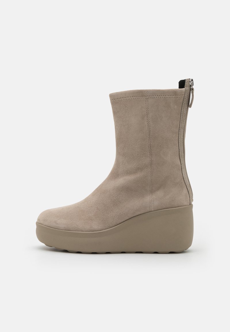 Beige Wildleder-Stiefelette mit Wedge-Sohle, seitlichem Reißverschluss, glatter Textur, runder Zehenform und minimalen Nähdetails.