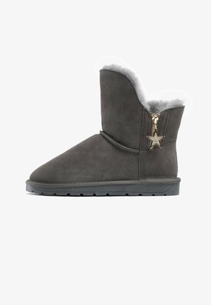 Graue Wildleder-Stiefelette mit fellgefüttertem Innenleben, flacher Gummisohle und goldfarbigem, sternförmigem Reißverschlussakzent an der Seite. Glatte Textur, runde Zehenform.