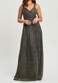 Maxi sukienka w ciemnym metalicznym materiale; posiada dekolt w serek, krzyżujące się bodice oraz zwiewną plisowaną spódnicę, z cienkimi ramiączkami.