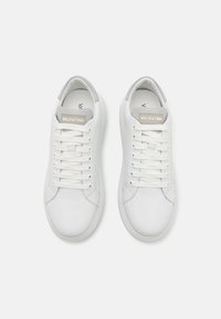 Witte lederen sneakers met een gladde textuur, ronde neus, platte veters en een lichtgrijze label op de tong met "VALENTINO."