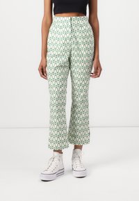 Mønstrete grønne og off-white capribukser med bølgete design, laget av lett stoff, kombinert med hvite høye sneakers.