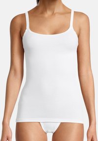 Top bianco senza maniche con spalline sottili, realizzato in tessuto morbido, caratterizzato da un design aderente e una texture liscia, ideale per essere indossato a strati o per un look casual.