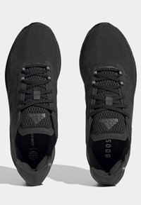 Černé sportovní boty z prodyšné síťoviny s texturovaným povrchem. Mají ploché tkaničky a výrazné logo na jazyku.