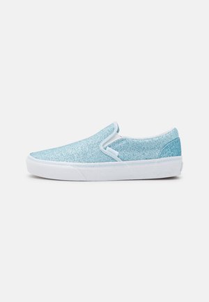 Zapatilla tipo slip-on azul claro con purpurina y suela blanca, vista de lado sobre fondo blanco liso.