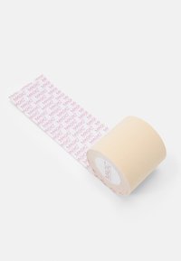 Beige tape-rull med et rosa gjentakende "MAGIC" mønster på baksiden. Rullen har en glatt tekstur og en sylinderform.