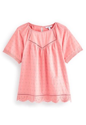Blouse rose à manches courtes avec broderie ajourée, ourlet festonné, dentelle aux manches et fermeture par bouton goutte d'eau au dos du col.