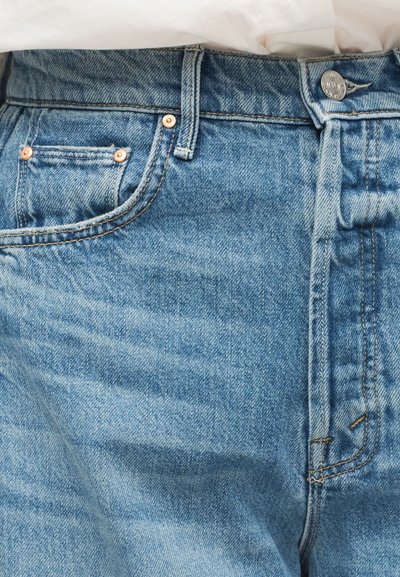 Φωτεινά μπλε τζιν με κλασικό σχέδιο, πέντε τσέπες, χάλκινες κουμπιά και αντίθετη ραφή. Μαλακή υφή με ελαφριά ξεθώριασμα.