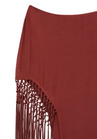 Haut en tissu rouge avec un décolleté en scoop et des détails en franges nouées complexes le long de l'ourlet, apportant de la texture et un élément de design unique.