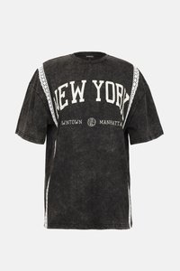 Svart oversized t-skjorte med "NEW YORK" trykk i hvitt, med blonder detaljer langs skuldrene og en slitt tekstur.
