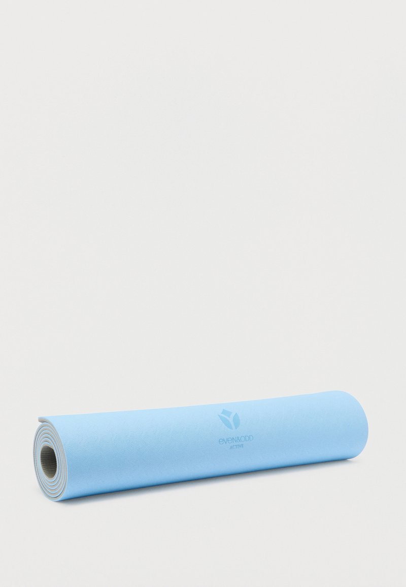 Μπλε στρώμα γιόγκα τυλιγμένο, κατασκευασμένο από υφή καουτσούκ, με διακριτικό λογότυπο και αντίθετο λευκό κάτω μέρος. Ομαλή επιφάνεια για καλύτερη πρόσφυση.