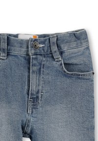 Jeans in denim azzurro chiaro con vita classica, bottone argentato e tessuto strutturato. Presenta una tasca frontale e cuciture a contrasto.