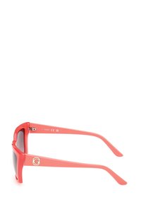 Occhiali da sole in plastica corallo con una montatura quadrata spessa, lenti scure e un accento dorato con il logo sul lato, design elegante e superficie liscia.