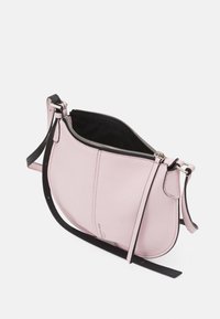 Borsa a tracolla in pelle rosa con finitura texture, tracolla nera e zip argentata. La parte superiore aperta rivela un interno nero.