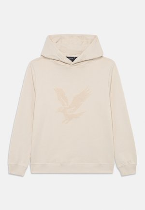 Ecrufarbener Kapuzenpullover mit langen Ärmeln und einem strukturierten Adlerdesign in der Mitte auf der Vorderseite.