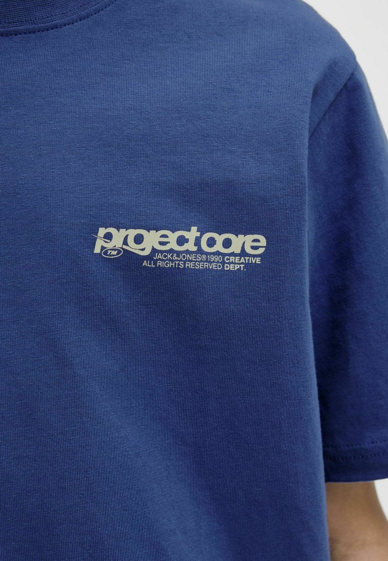 Marineblå t-shirt lavet af blød bomuld med et hvidt grafiklogo på brystet. Korte ærmer med en klassisk rund halsudskæring.