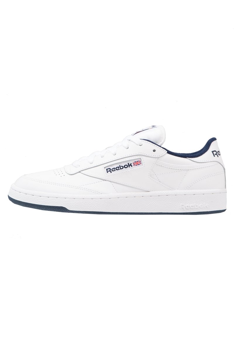 Baskets en cuir blanc avec des accents bleu marine, dotées d'un bout rond, d'un système à lacets et d'une semelle en caoutchouc texturée. Logo Reebok sur le côté.
