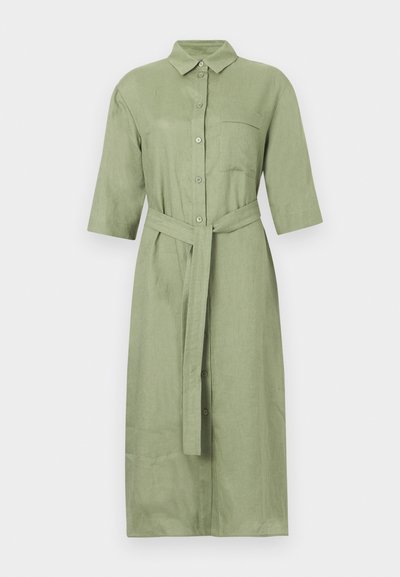 Μίντι φόρεμα σε χρώμα φασκόμηλο, με κουμπιά, μανίκια τρία τέταρτα, γιακά, τσέπη στο στήθος και ζώνη από το ίδιο ύφασμα δεμένη στη μέση.