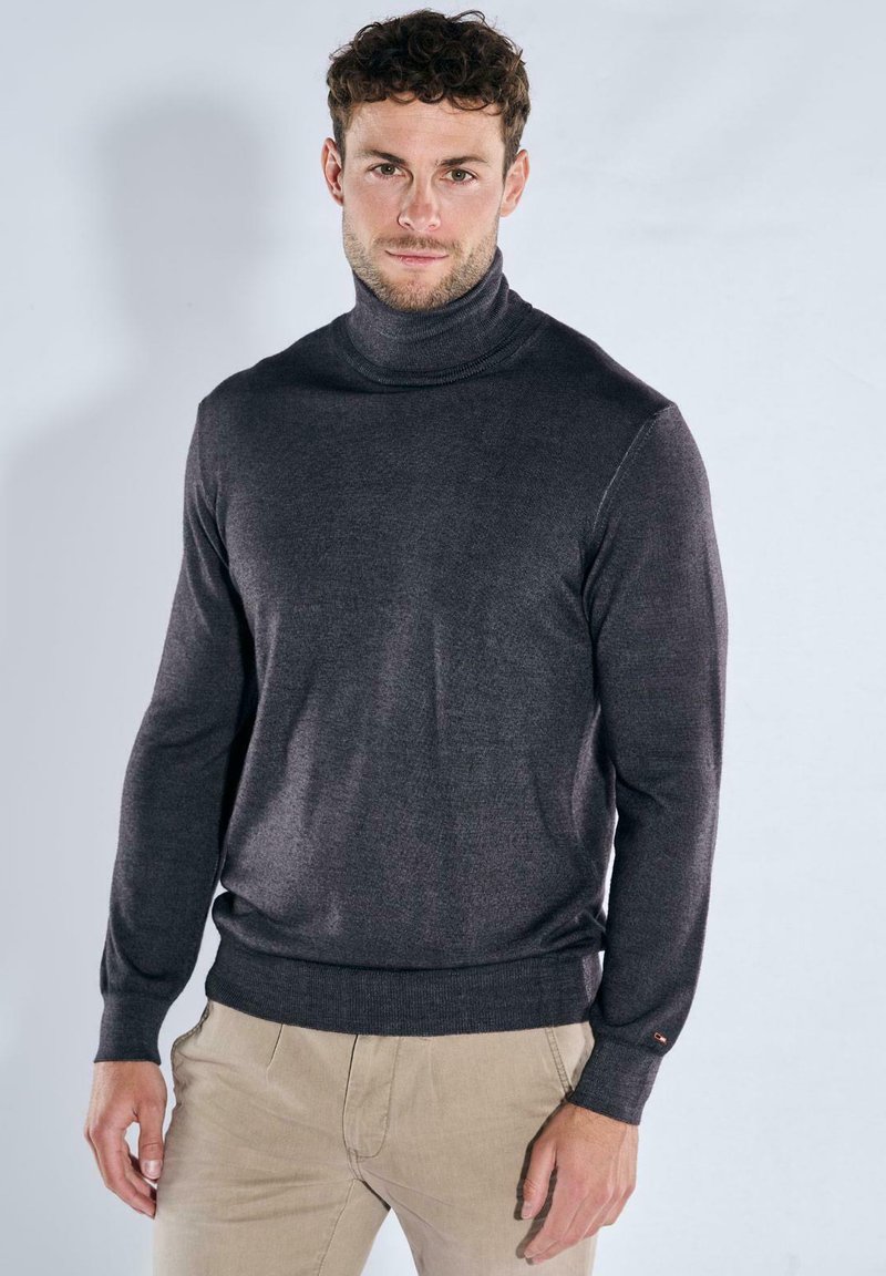 Dark gray turtleneck sweater made of smooth material, featuring a fitted design, long sleeves, and ribbed cuffs and hem.