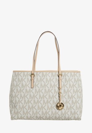 Beżowa torba typu tote Michael Kors z powtarzającym się wzorem logo "MK", beżowymi paskami oraz okrągłą złotą zawieszką "MK" wiszącą na jednym pasku.
