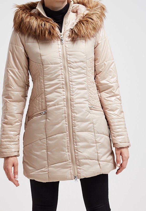 Giacca puffer beige con cappuccio in pelliccia sintetica, chiusura con zip, pannelli testurizzati e tasche laterali con zip. Presenta una vestibilità rilassata e maniche lunghe.
