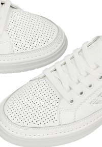 Bílé kožené tenisky s perforovaným designem, plochými tkaničkami, zaoblenou špičkou a texturovanou gumovou podrážkou. Minimalistický styl bez viditelných značek.