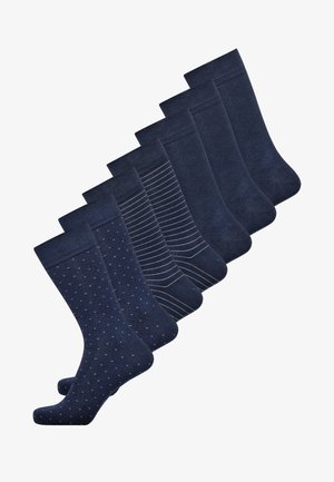 Sæt med syv marineblå sokker med forskellige designs: prikker, striber og ensfarvede mønstre, alle med en glat tekstur og ribbede manchetter.