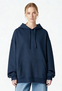 Tengerészkék, túlméretezett kapucnis pulóver pamutkeverék anyagból. Elöl zsebbel, állítható húzózsinóros kapucnival, valamint bordázott passzékkal az ujj- és derékrészen.