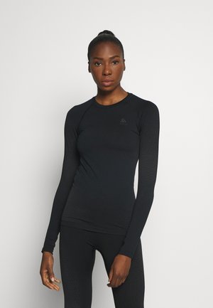 Black long-sleeve athletic top with textured sleeves, crew neckline, and subtle logo on chest. Form-fitting design, made from stretchy fabric.