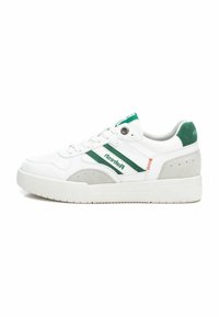 Zapatillas blancas con acentos verdes, materiales de ante y cuero, punta redonda, suela plana y marca lateral con rayas verdes y naranjas.