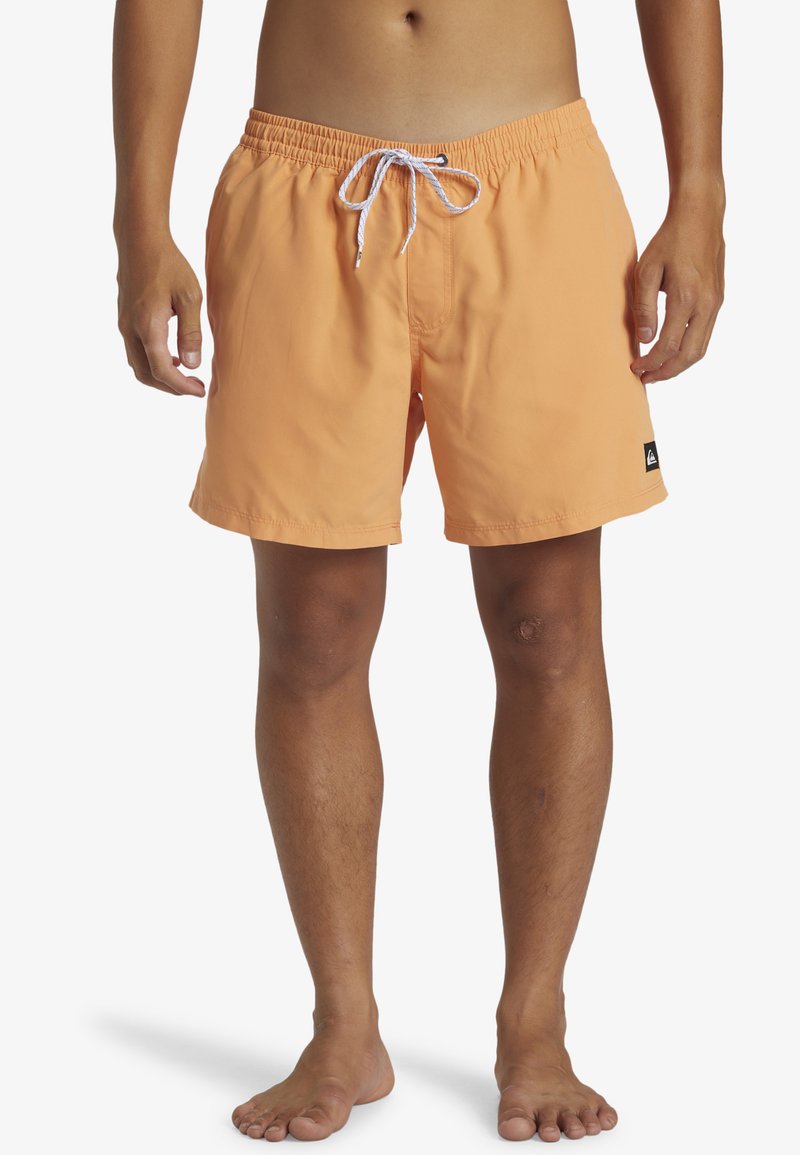 Bañadores naranjas con cintura elástica y cordón blanco. Cuenta con bolsillos laterales y un pequeño logo negro de la marca en el dobladillo.