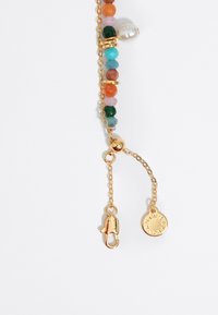 Collana con perline multicolori caratterizzata da hardware in oro, perle texturizzate e un accento di perla. Include una chiusura a granchio e un'etichetta con il logo.