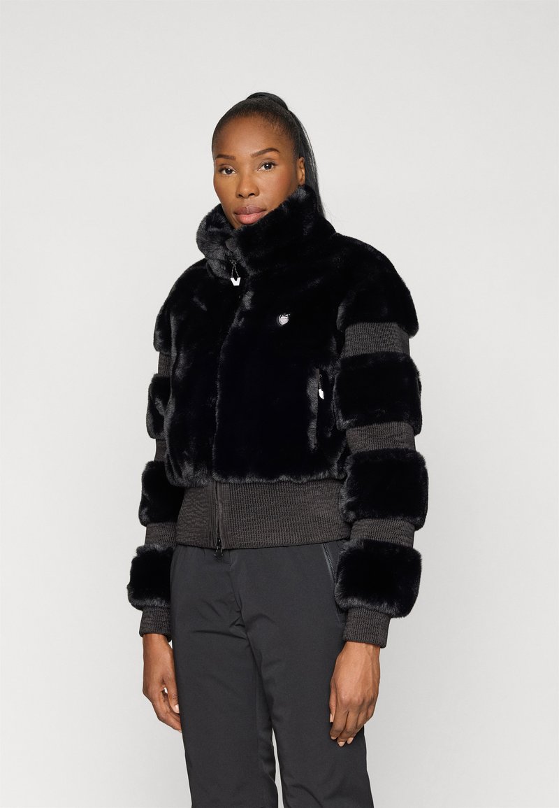 Jacket de pêlo preto com um colarinho alto, apresentando uma mistura de painéis brilhantes e texturizados. Punhos e hem com malha canelada e fecho de zip.