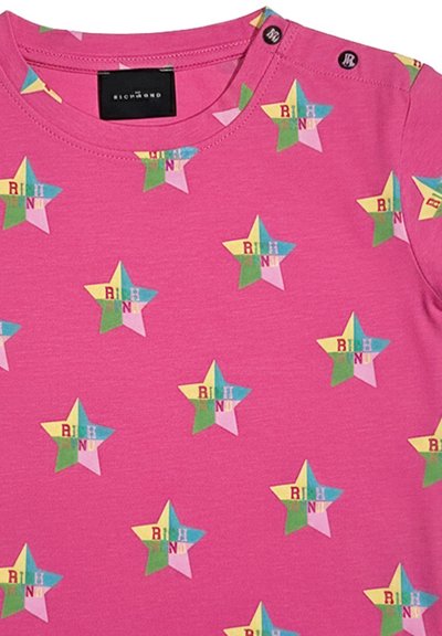 Tessuto rosa con stelle multicolori che presentano le lettere "RICHN" e due bottoni neri vicino alla spalla.