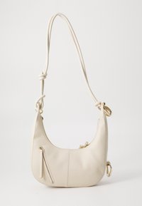 Cream leather shoulder bag with a curved shape, featuring a zippered front pocket, gold accents, and a knotted shoulder strap.