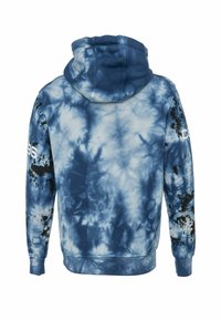Blauwe tie-dye hoodie met een grote capuchon, verschillende blauwtinten en zwarte spetteraccenten op de mouwen. Heeft geribbelde boorden aan de mouwen en zoom.