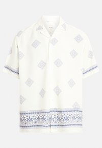 Chemise blanche à manches courtes avec des motifs géométriques bleus, dotée d'un devant à boutons et d'une garniture décorative bleue le long du bas et des manches.