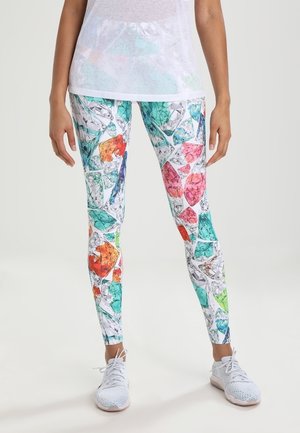 Kleurige leggings met een geometrisch diamanten patroon in tinten van oranje, roze, groen en turquoise op een witte achtergrond.