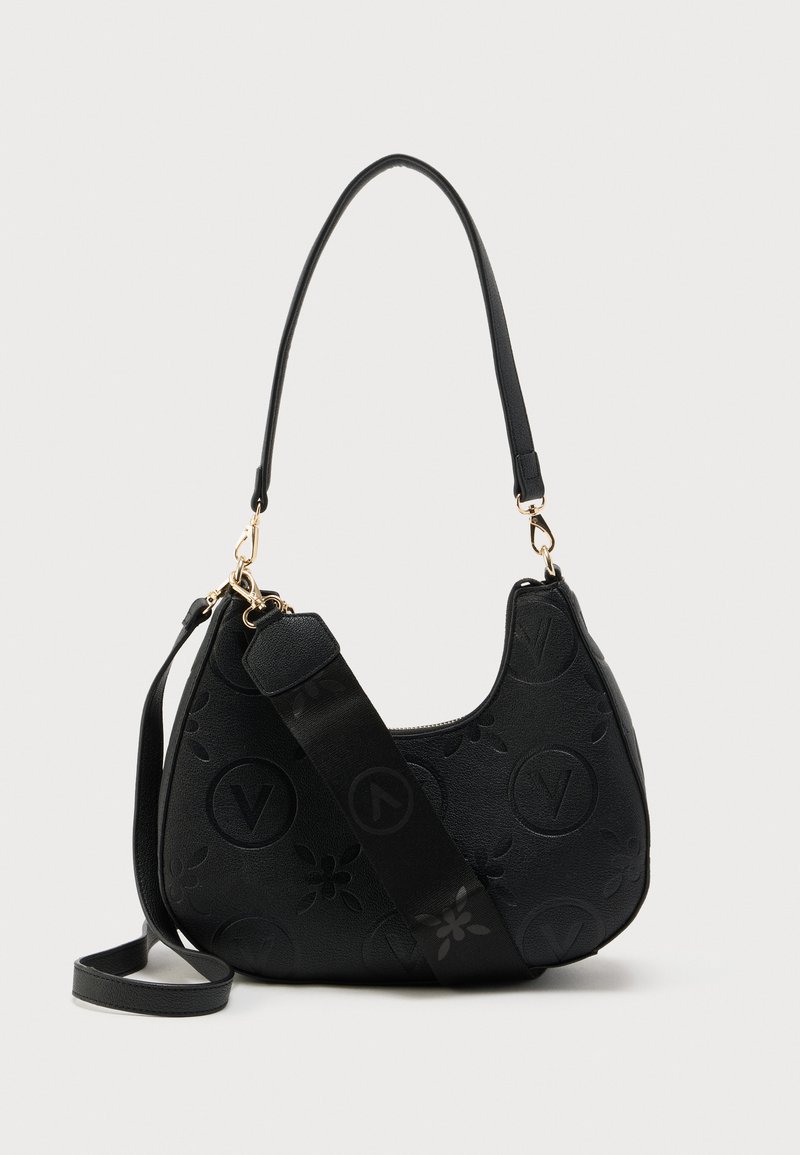 Bolso negro en forma de media luna con patrones florales en relieve y círculos con la letra "V", equipado con correas desmontables para el hombro y una correa ajustable para llevar cruzado.