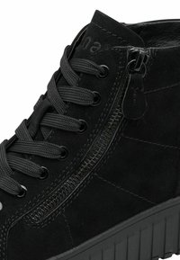 Schwarze Wildleder-Ankle-Boots mit dicker Sohle, runden Schnürsenkeln, seitlichem Reißverschluss und strukturierten Nähdetails im Obermaterial.