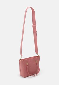Pink textured handbag with a structured shape, double handles, and a detachable shoulder strap. Features gold hardware accents.