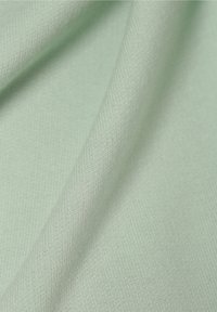 Světlá mentolová látka s hladkým povrchem, která má jemný, konzistentní pletený vzor a mírnou pružnost.